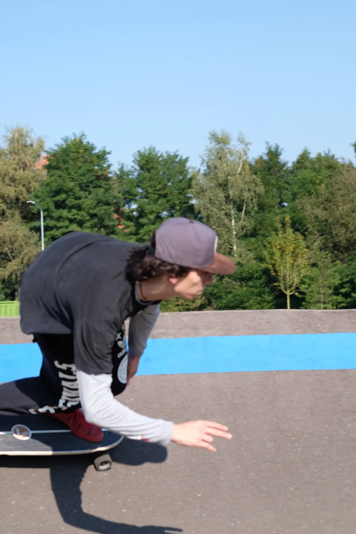 Skater carving on a paved track with a blue stripe