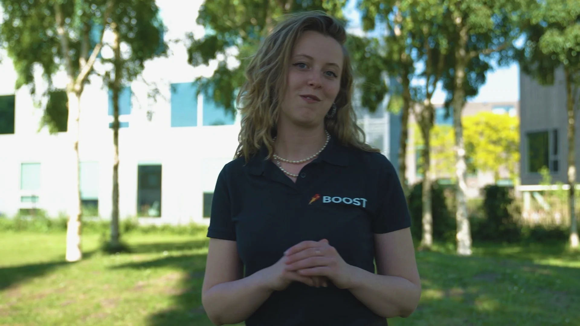 Boost team member speaking outdoors in a branded polo