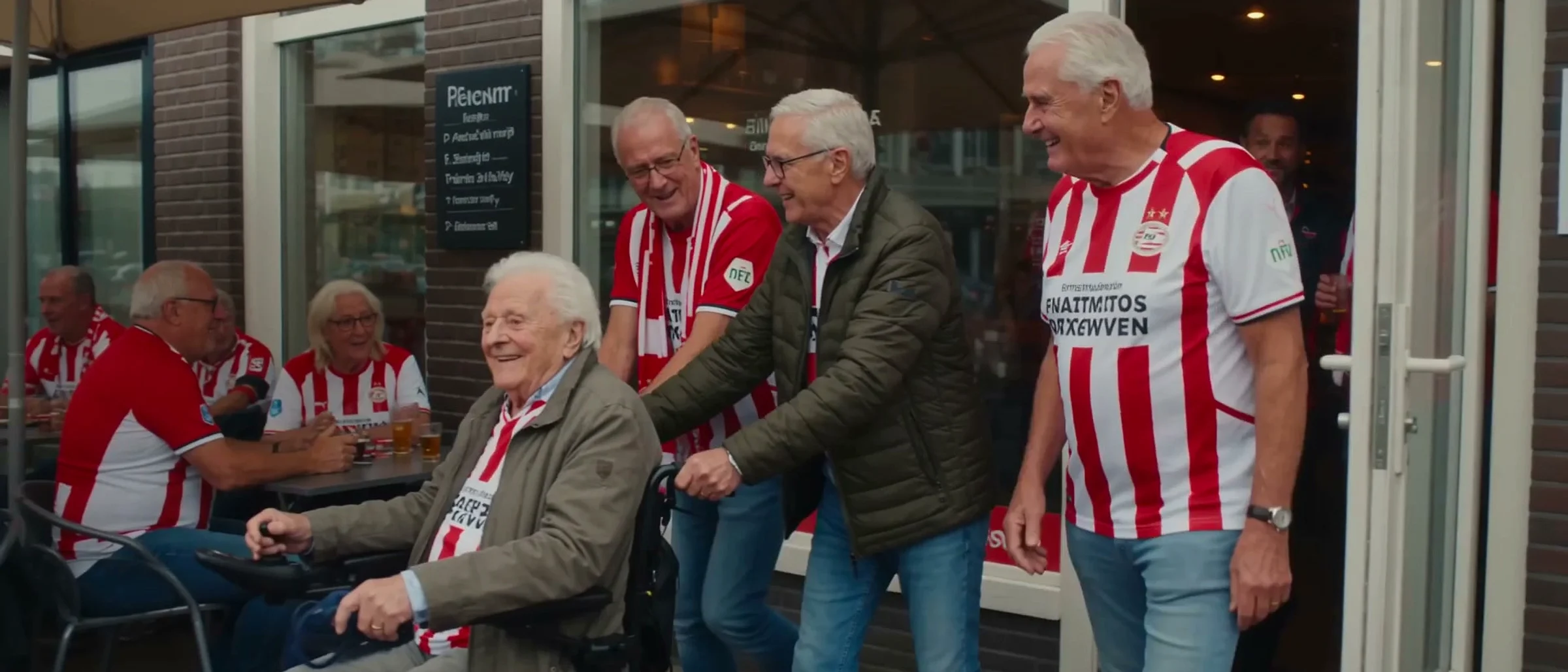 Four generations of PSV fans on a city sidewalk, smiling in club colours
