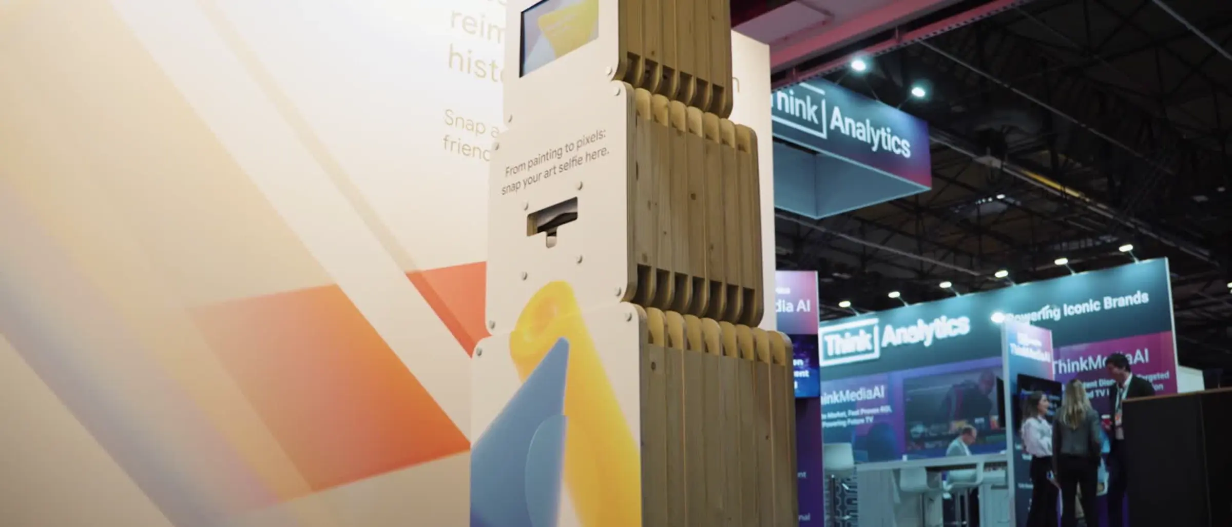 WeSmile modular AI photobooth on an exhibition floor with branded wall graphics