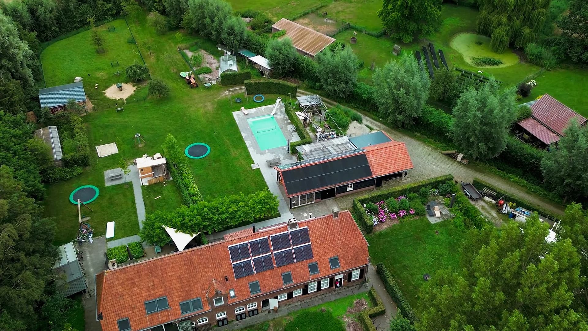 Aerial view across the farmhouse roof, solar panels and garden