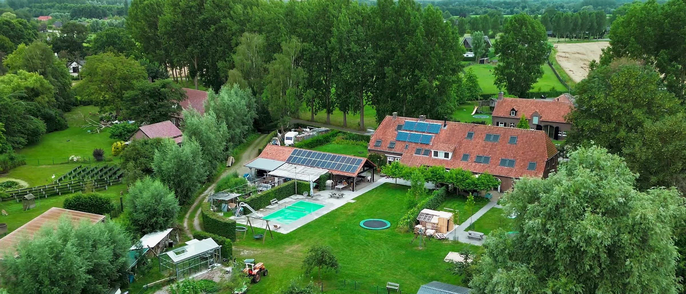 Aerial view of the Woonboerderij farmhouse, gardens and pool